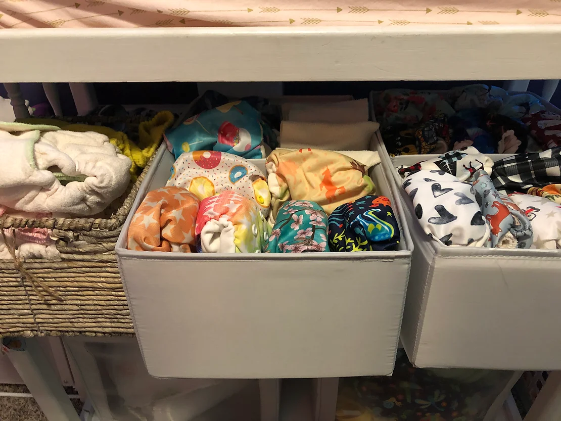 bins of cloth diapers under changing station