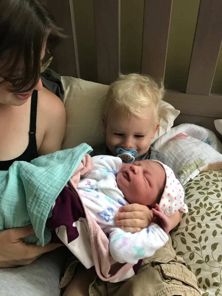 big brother holding little sister for the first time